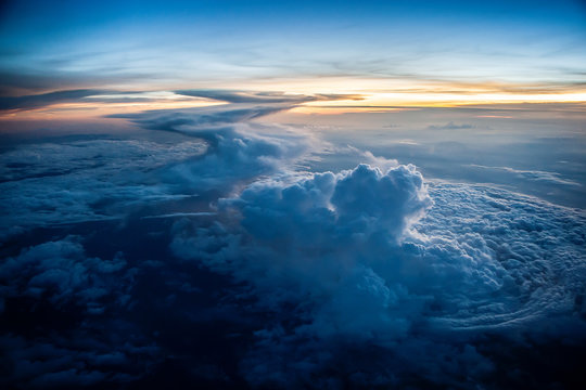 Aerial view of a cloudy sunset while flying above the clouds
