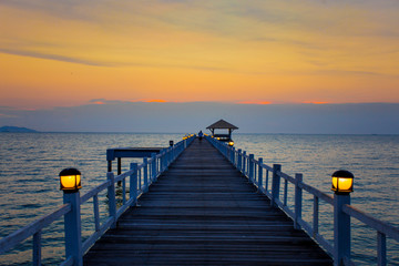 Fototapeta premium The wooden bridge on sea at sunset, Thailand.