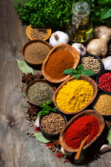 assortment of oriental spices on a wooden background, vertical top view