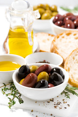 fresh organic olives, spices and bread on white background, vertical closeup