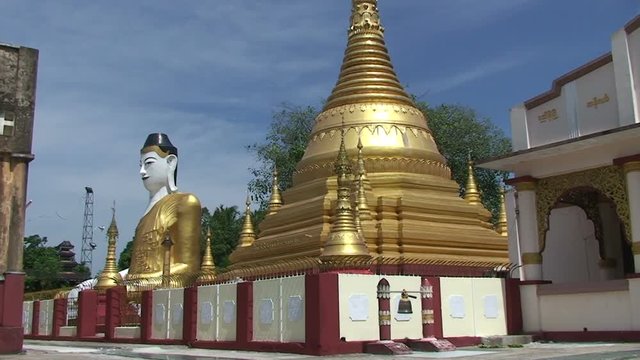 Pathein, Big Buddha statue behind a Pagoda
