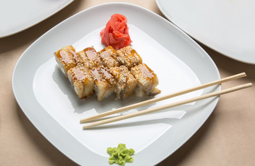 delicious rolls with eel and ginger on a white plate in a restaurant