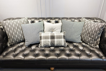 Modern fabric gray pillow on luxury leather sofa interior