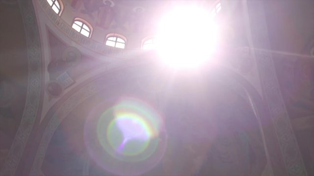 Sunlit church dome with orthodox paintings, frescos and icons. Steadycam shot