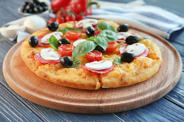 Delicious pizza and napkin on blue wooden background