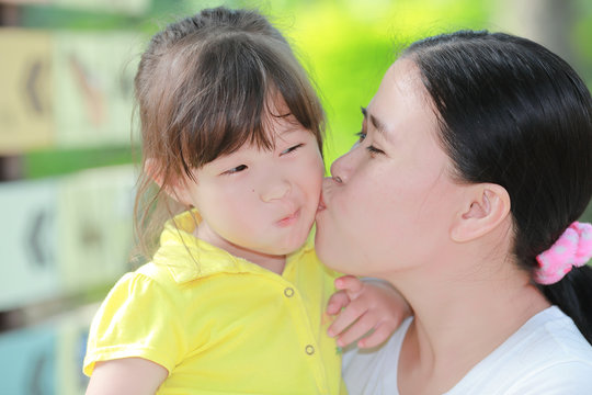 Mother kissing her daughter