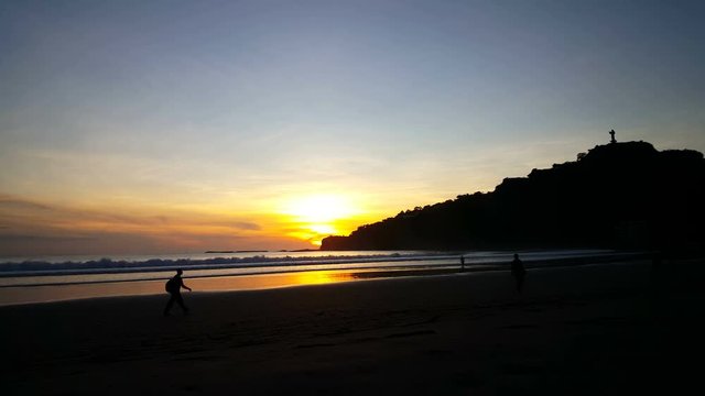 Men walking at sunset on the beach of San Juan del Sur