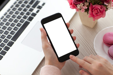 Women hands holding phone isolated screen near laptop in cafe