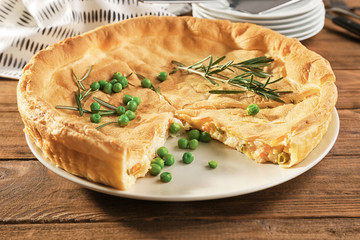 Tasty chicken pot pie with green peas on plate