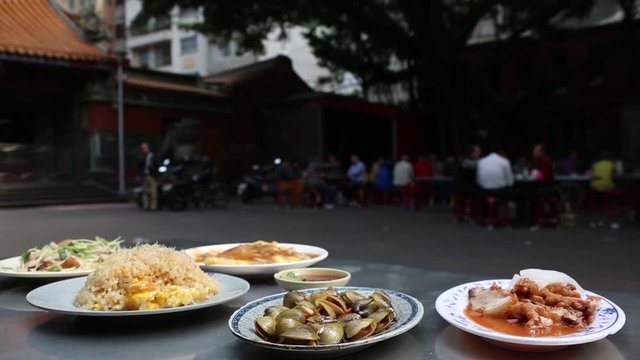 Several dishes with food in an open air restaurant at the Ci Sheng Temple in Taipei, Taiwan. Tzu Sheng Temple is a small temple in Tataocheng, one of Taipei's oldest neighborhoods.