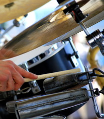 Latin jazz drummer performing a solo in concert outdoors.