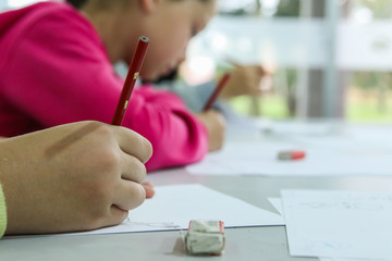 Children sketching on paper with pencils