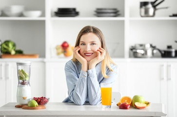 Obraz na płótnie Canvas Beautiful woman with glass of fresh juice in kitchen