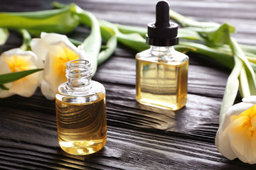 Composition with perfume and flowers on wooden table