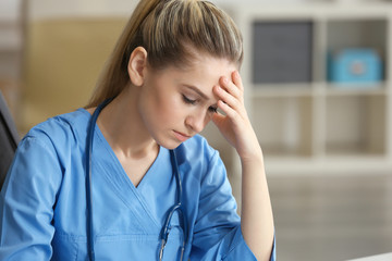 Tired medical assistant in her office