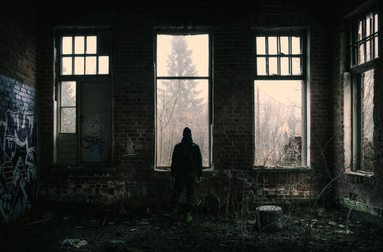 Lonely Depressed Man Standing At Dark Abandoned Factory.