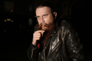 Bearded man smoking weed outdoors late in evening