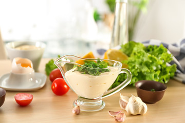 Delicious mayonnaise in gravy boat on kitchen table