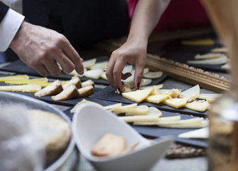 Hombre cogiendo queso en aperitivo