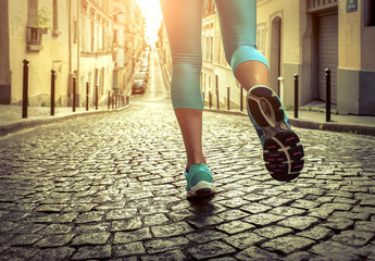 Running woman. Close-up view foots of runner jogging at sunny da