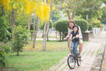 Asian  mother and son riding bicycle