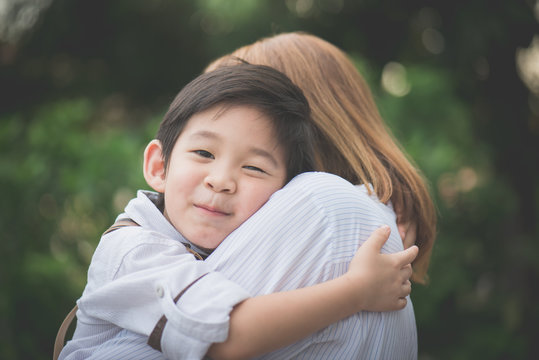 asian mother hugging with her son in the park