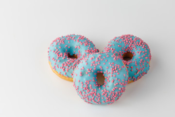 Donuts with blue glaze and pink sprinkles isolated on white background. Top view.