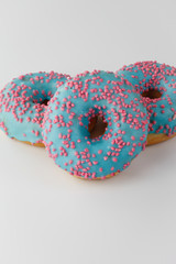 Donuts with blue glaze and pink sprinkles isolated on white background. Top view.