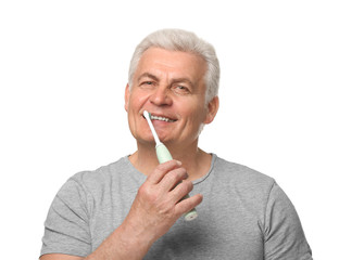 Senior man cleaning teeth on white background