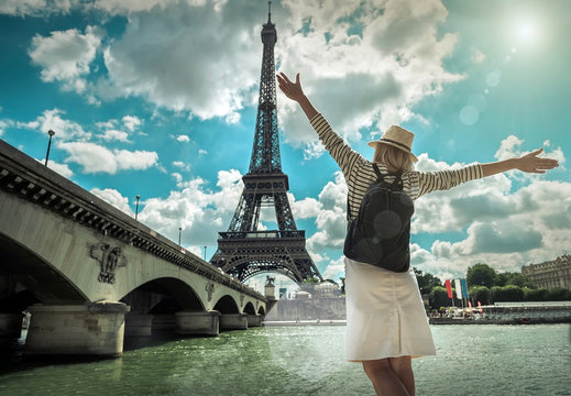 Woman tourist selfie near the Eiffel tower in Paris under sunlig