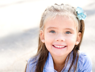 Portrait of adorable smiling little girl in the park