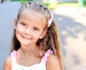 Portrait of adorable smiling little girl in the park