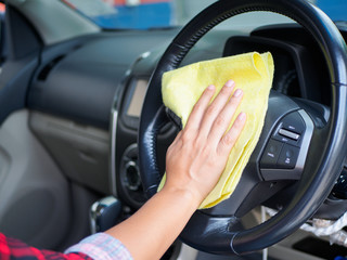 Hand cleaning interior car steering wheel with microfiber cloth