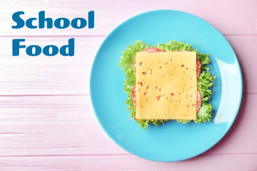 Plate with tasty food on wooden background, top view