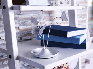 Books and decorations on white shelf at home