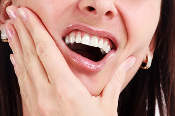 Obraz premium Closeup of woman in strong toothache pain with hands over face. Dental health and care concept.