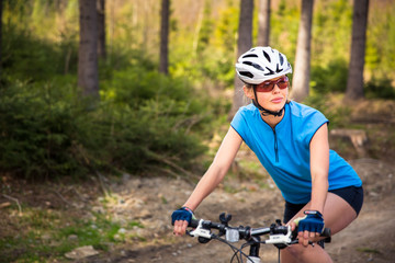 Pretty, young female biker outdoors on her mountain bike (shallow DOF; selective focus)