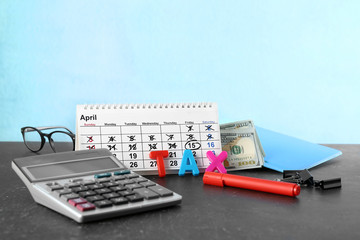 Calendar, word TAX and calculator on table