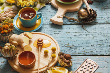 Cups with herbal tea and pieces of lemon, dried herbs and different decorations