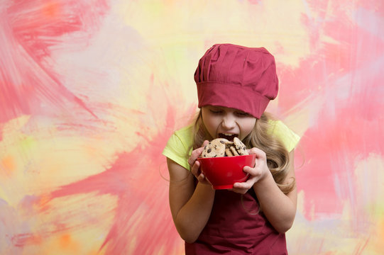 Girl Chef Or Child Cook In Hat Eating Cookie Food