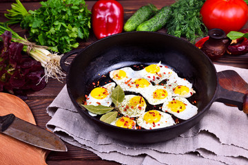 Fried quail eggs in a cast-iron frying pan