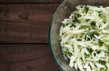 Cabbage salad with green parsley on a wooden background