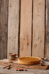 Obraz na płótnie Canvas Fresh Homemade Pumpkin Pie made for Thanksgiving. Pie on a wooden background. Rustic.