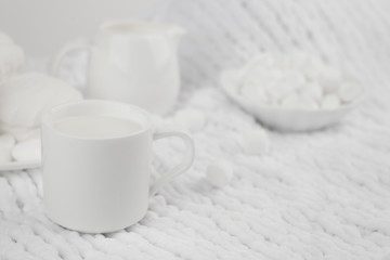 Fototapeta na wymiar white zephyr and milk in white dishes on white background, monochrome setting, high key
