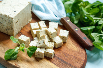 Tofu sliced on a wooden board. Love for a healthy vegan food concept