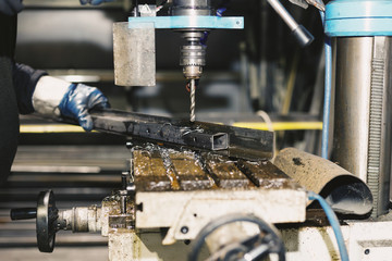 Industrial worker at the factory drill closeup