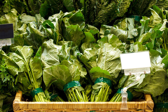 many bunch of fresh kailan in basket with blank tag label