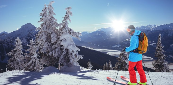 Composite image of skier with yellow backpack skiing 