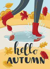 Girls or kids legs in rubber boots playing in the puddle. Falling leaves arround. Children jumping and splashing through the puddles in park in the Fall. Hello Autumn concept.