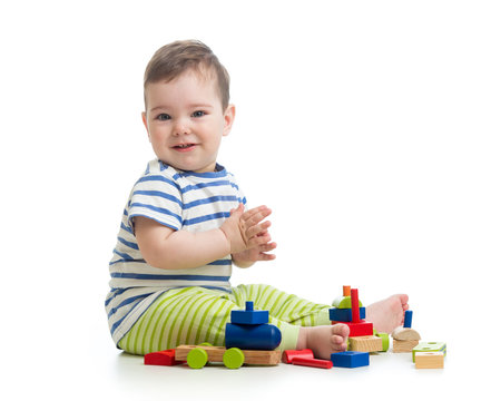 Baby boy playing with blocks toys. Isolated on white.